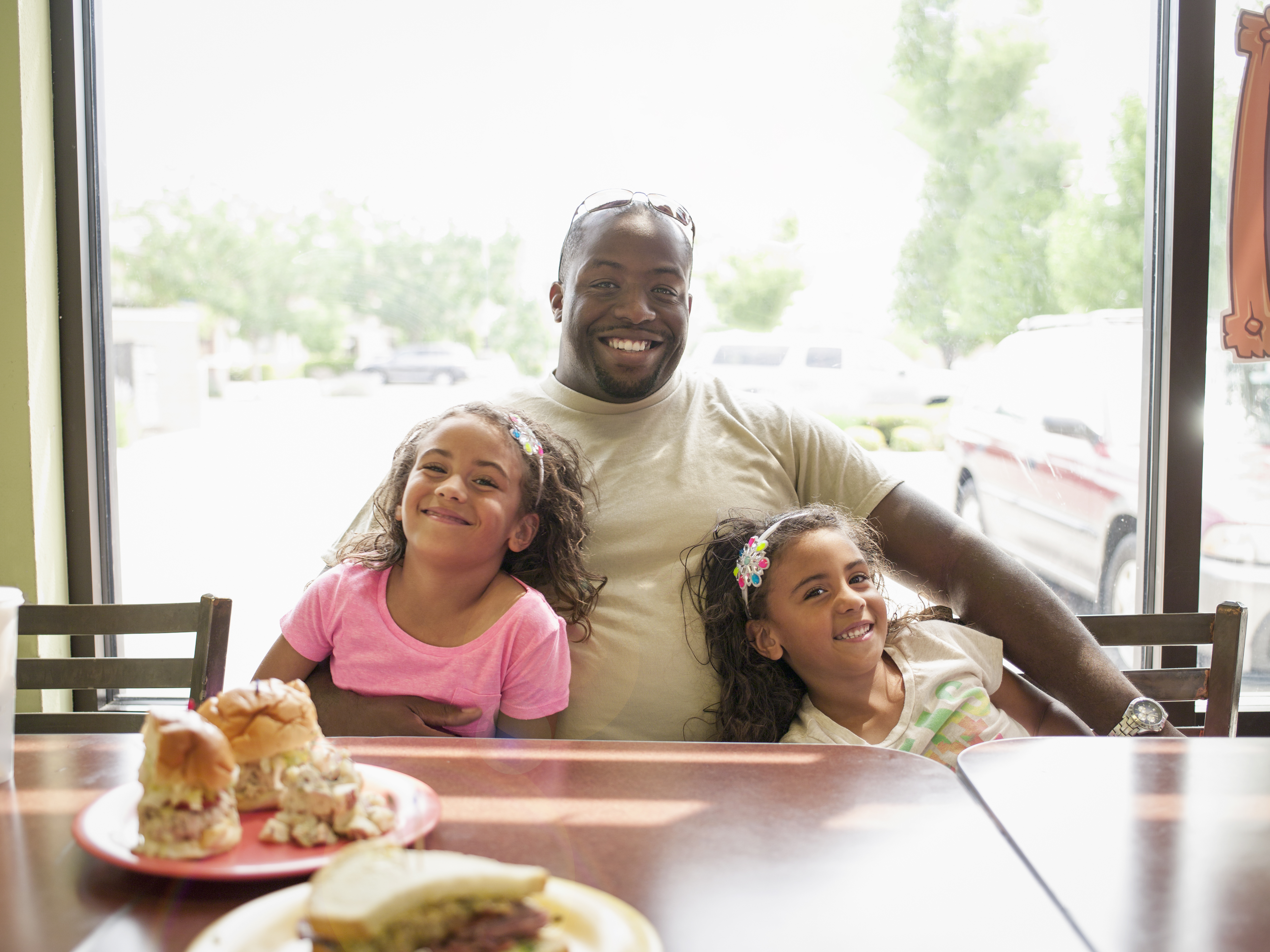 Father and twin daughters in restaurant