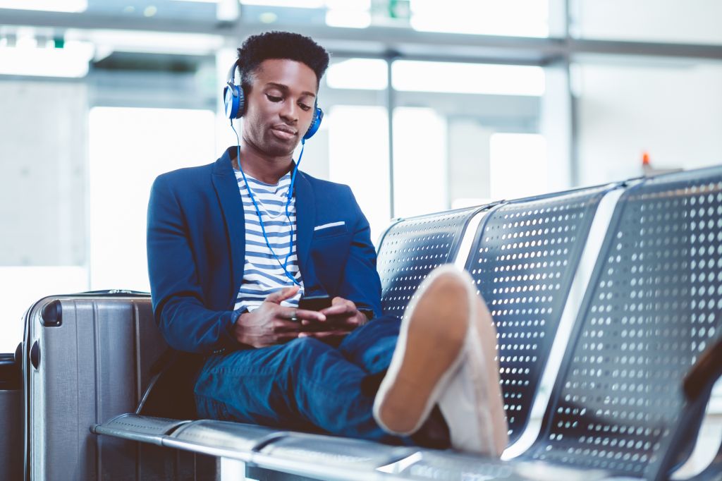 Young african man waiting for flight at airport lounge