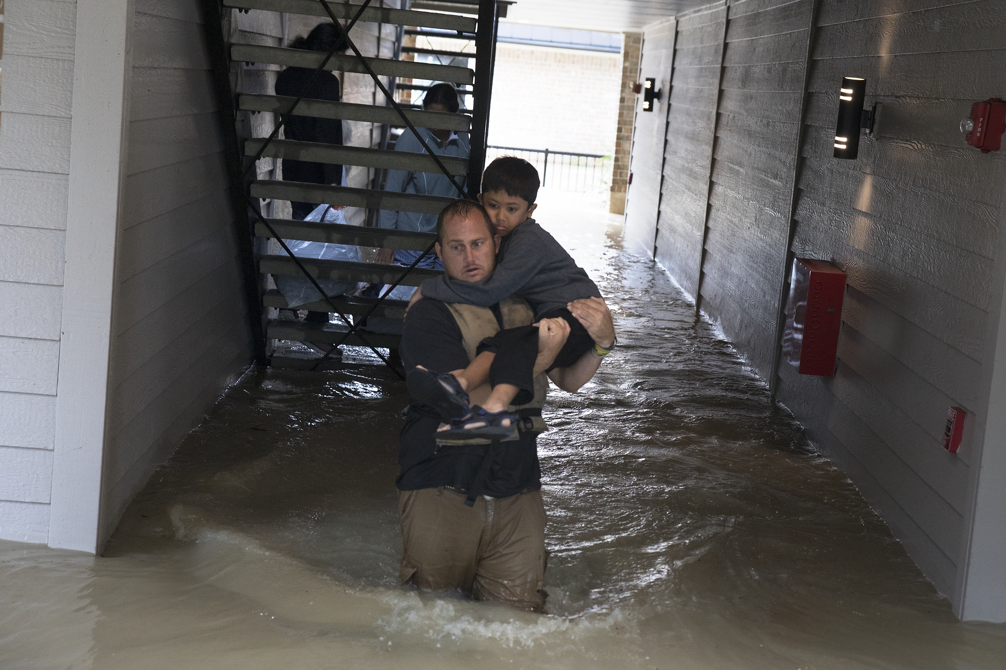 Police and volunteers rescue residents flooded by the San Jacinto river in Kingwood, Texas