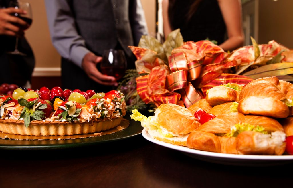 Friends sharing wine, food, appetizers. Holiday dining.