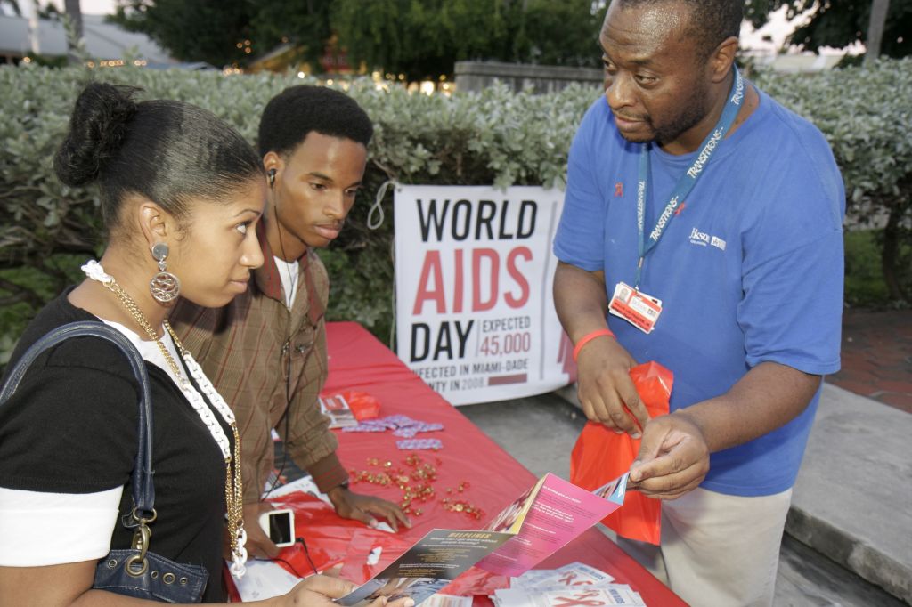 Man showing a couple sexually transmitted disease brochures for World AIDs Day