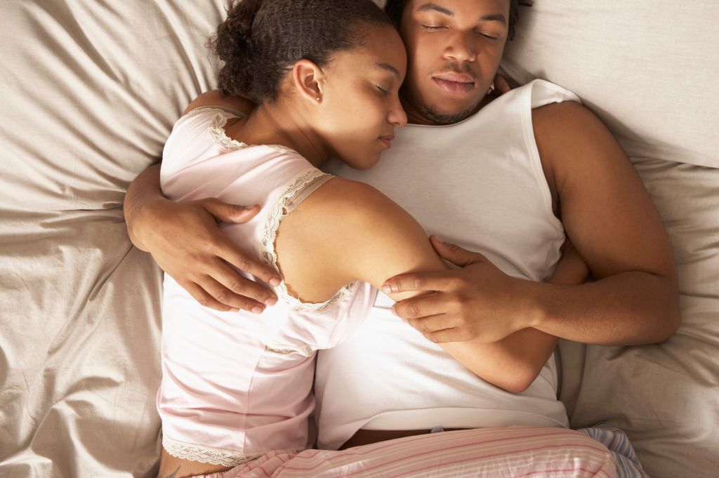 Couple cuddling and sleeping in bed