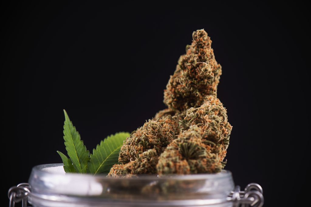 Close-Up Of Drugs In Jar Against Black Background