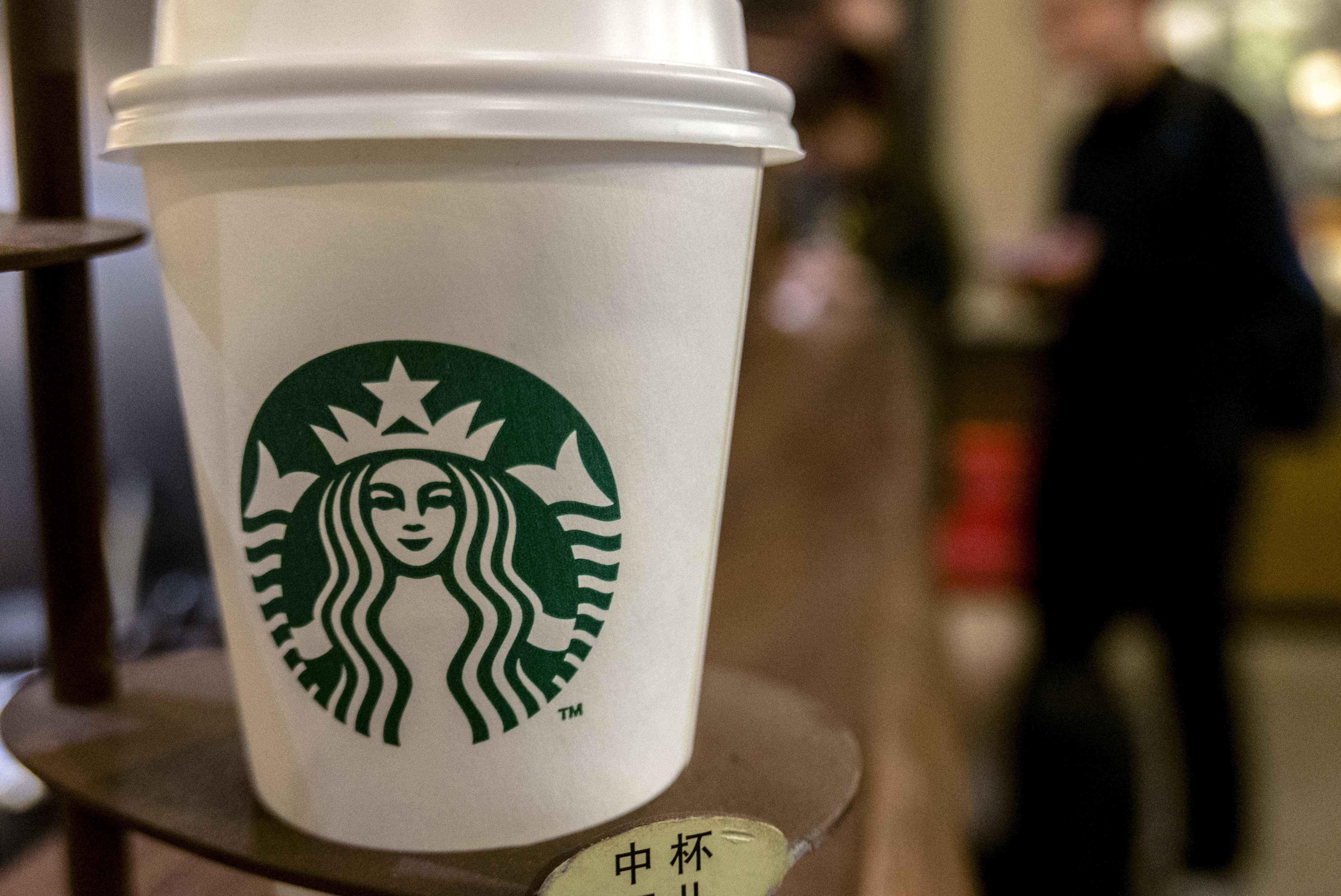 A Starbucks coffee cup on table. Starbucks is growing fast...