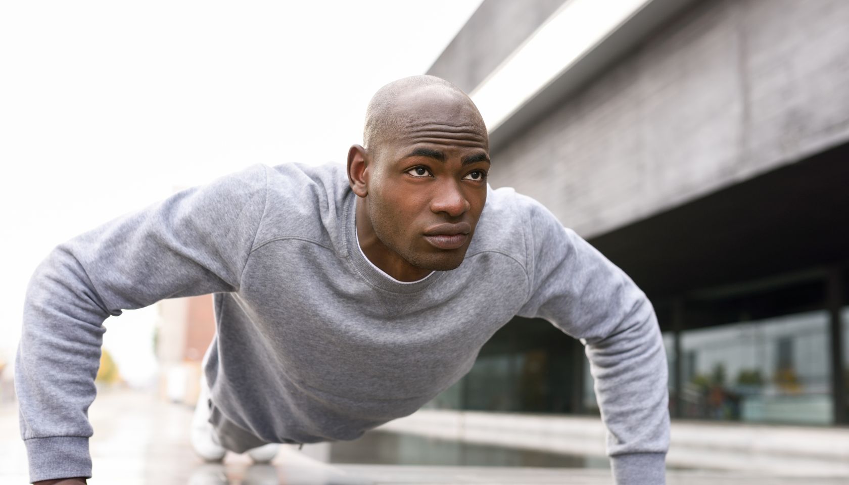 Man Doing Push-Ups On Footpath