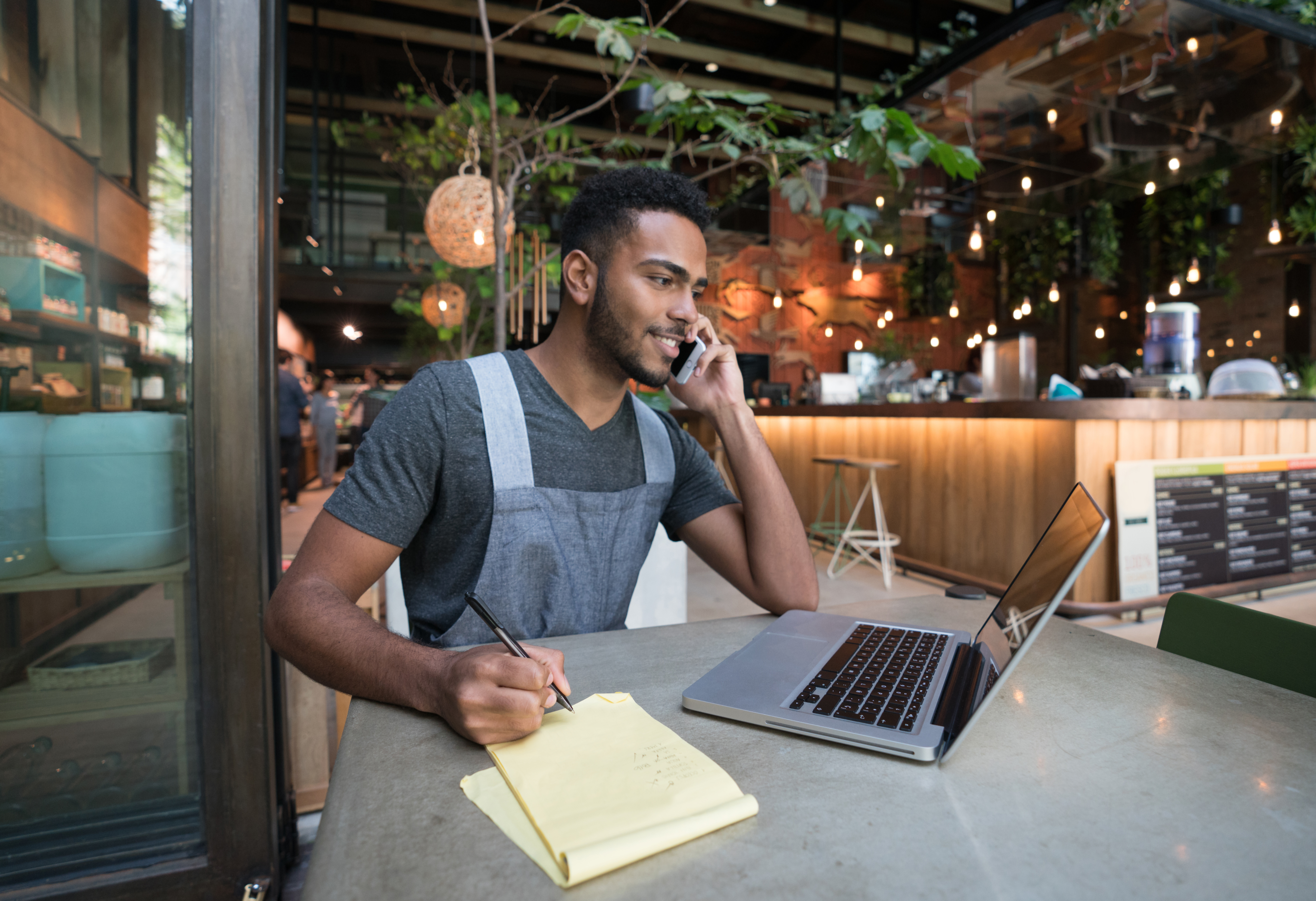 Restaurant manager talking on the phone and using a laptop computer