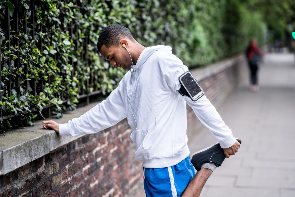 Runner stretching his legs on the street