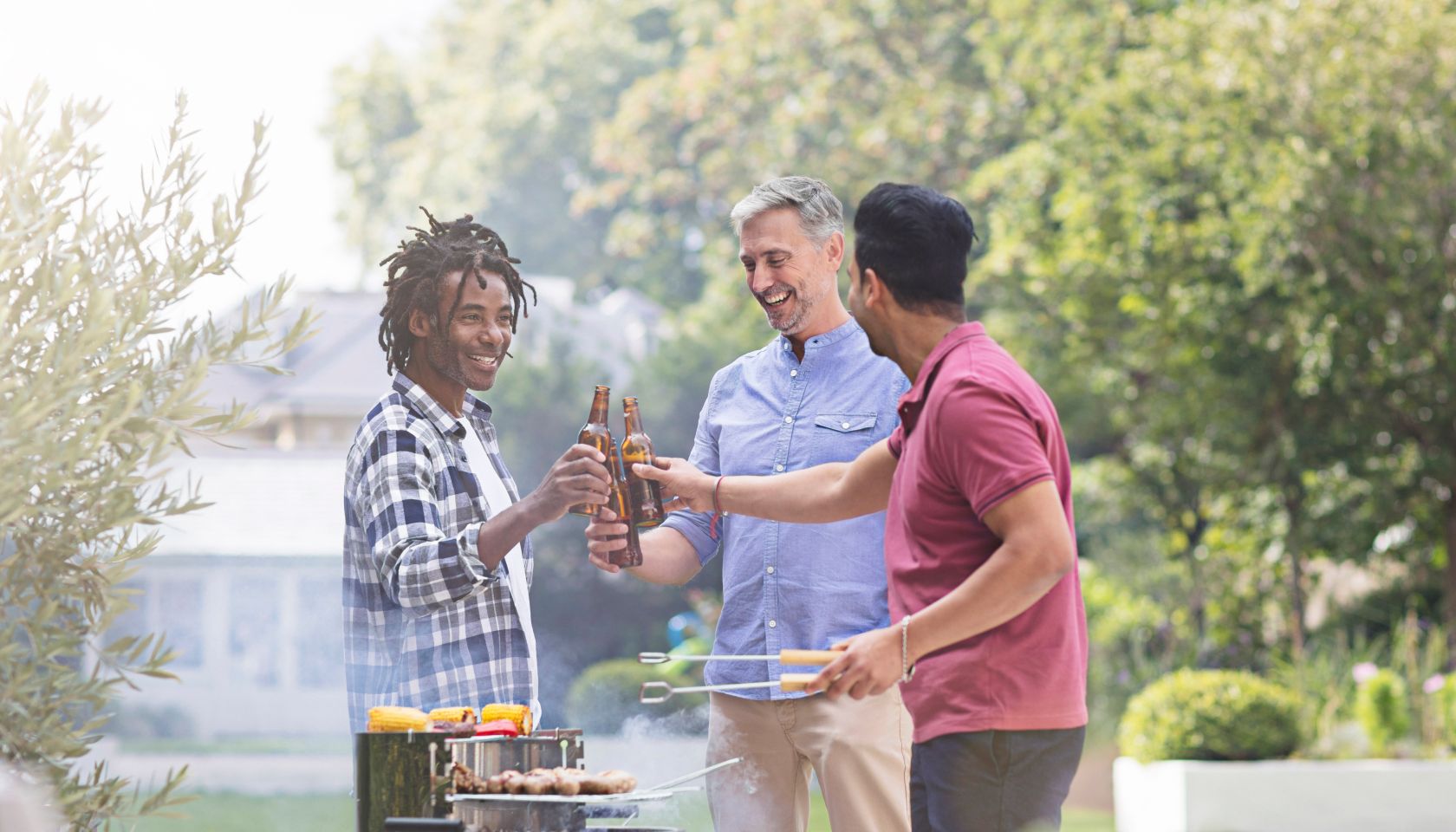 Happy male friends raising toast with beer bottles