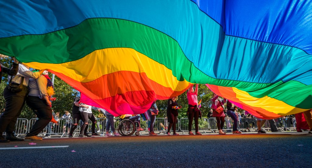 Gay Pride Parade-People marching with a large Flag, Reykjavik, Iceland