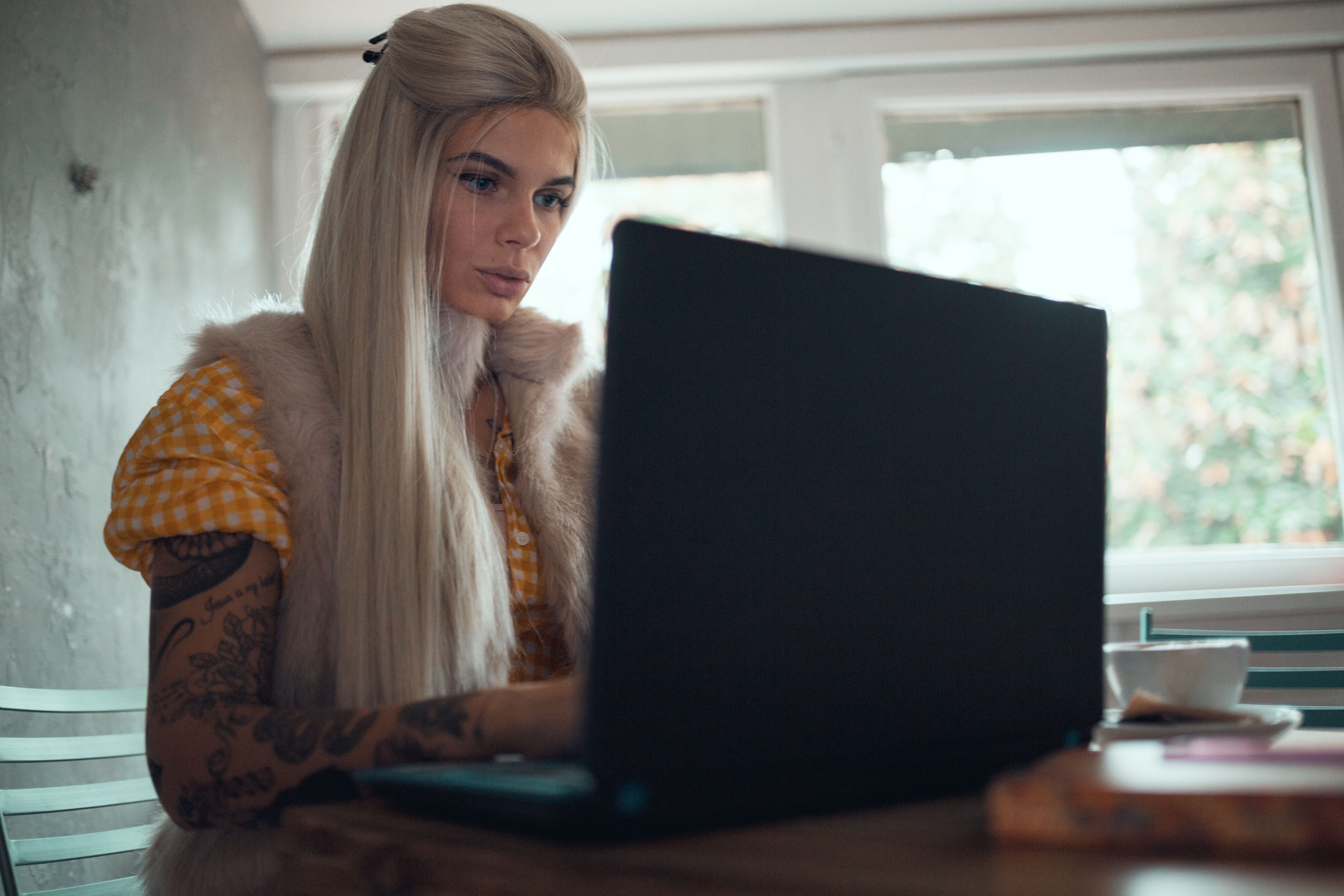 Young woman working and using laptop inside the coffee bar