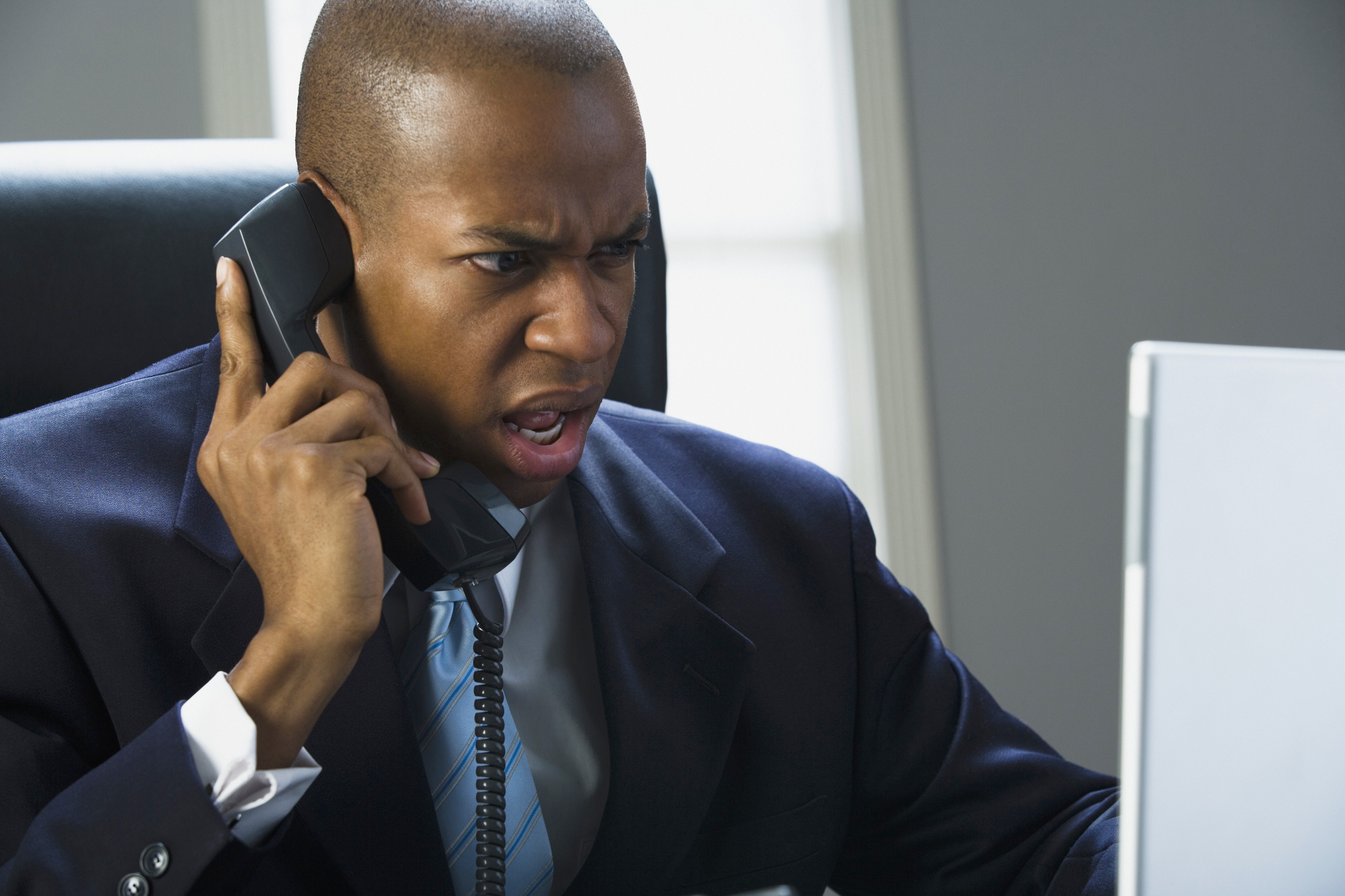 Businessman working on a laptop computer and talking on the phone
