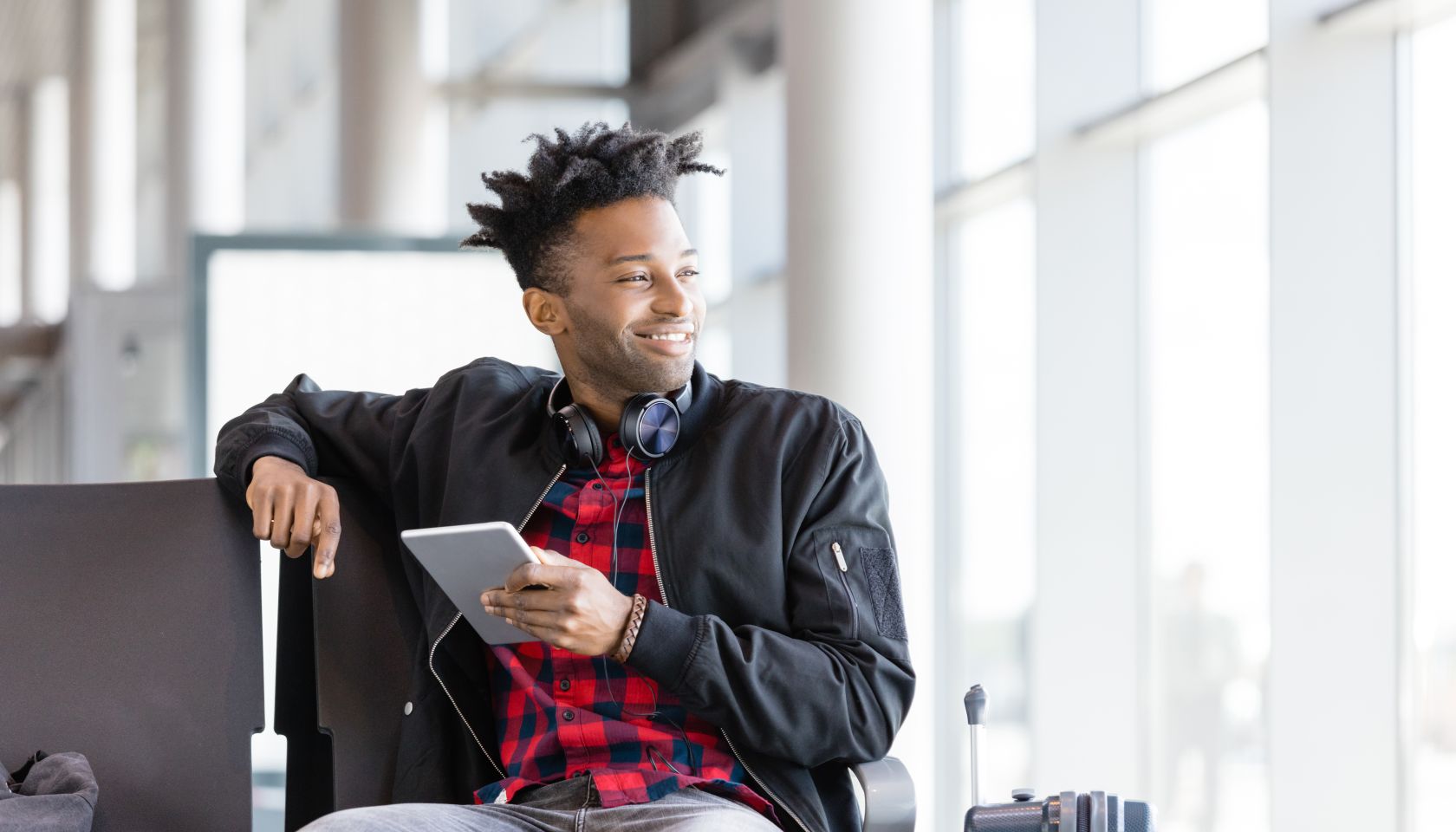 Young african using digital tablet in airport lounge