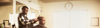 Barber in traditional barber shop shaving man's head