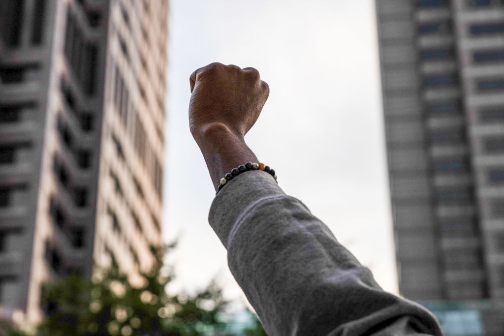 A protester holds up a fist outside the state house during...