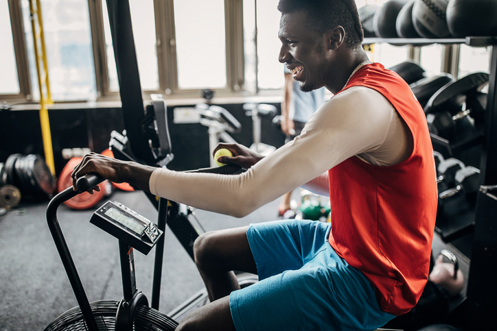 One young man volleyball player training on exercise bike