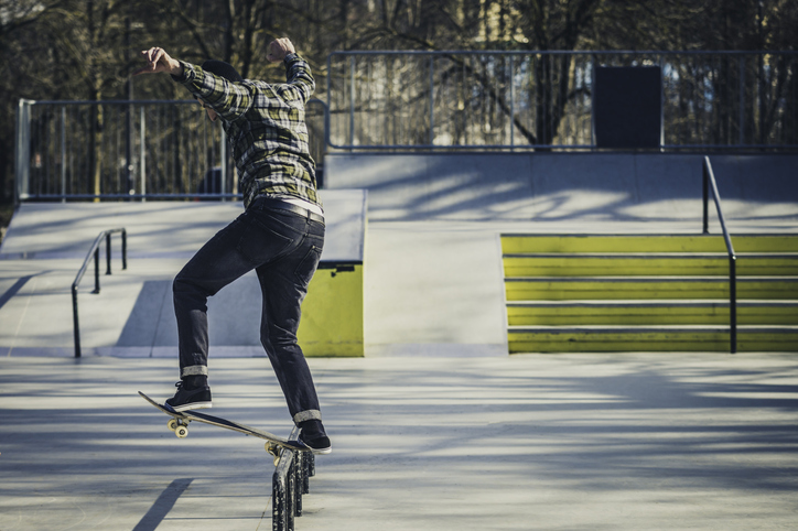 Skateboarder sliding on a rail in the skatepark
