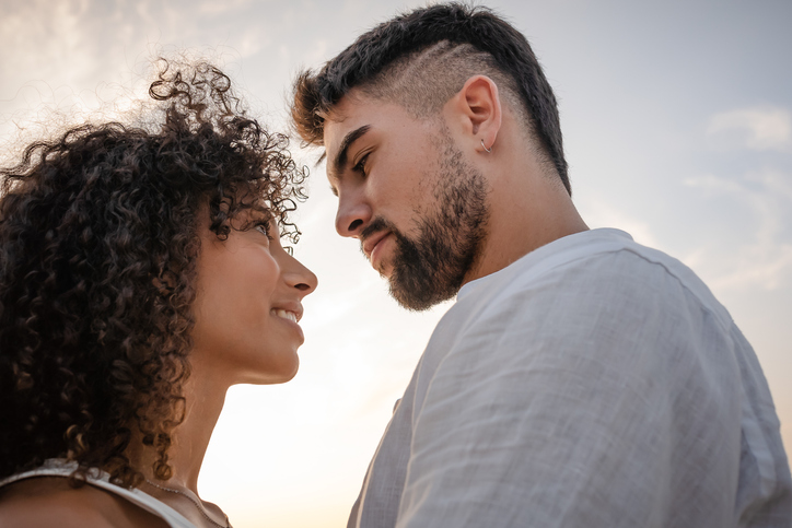 Close-Up Of Couple Embracing While Standing Against Sky
