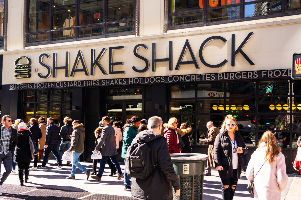 Pedestrians walk past an American fast casual restaurant...