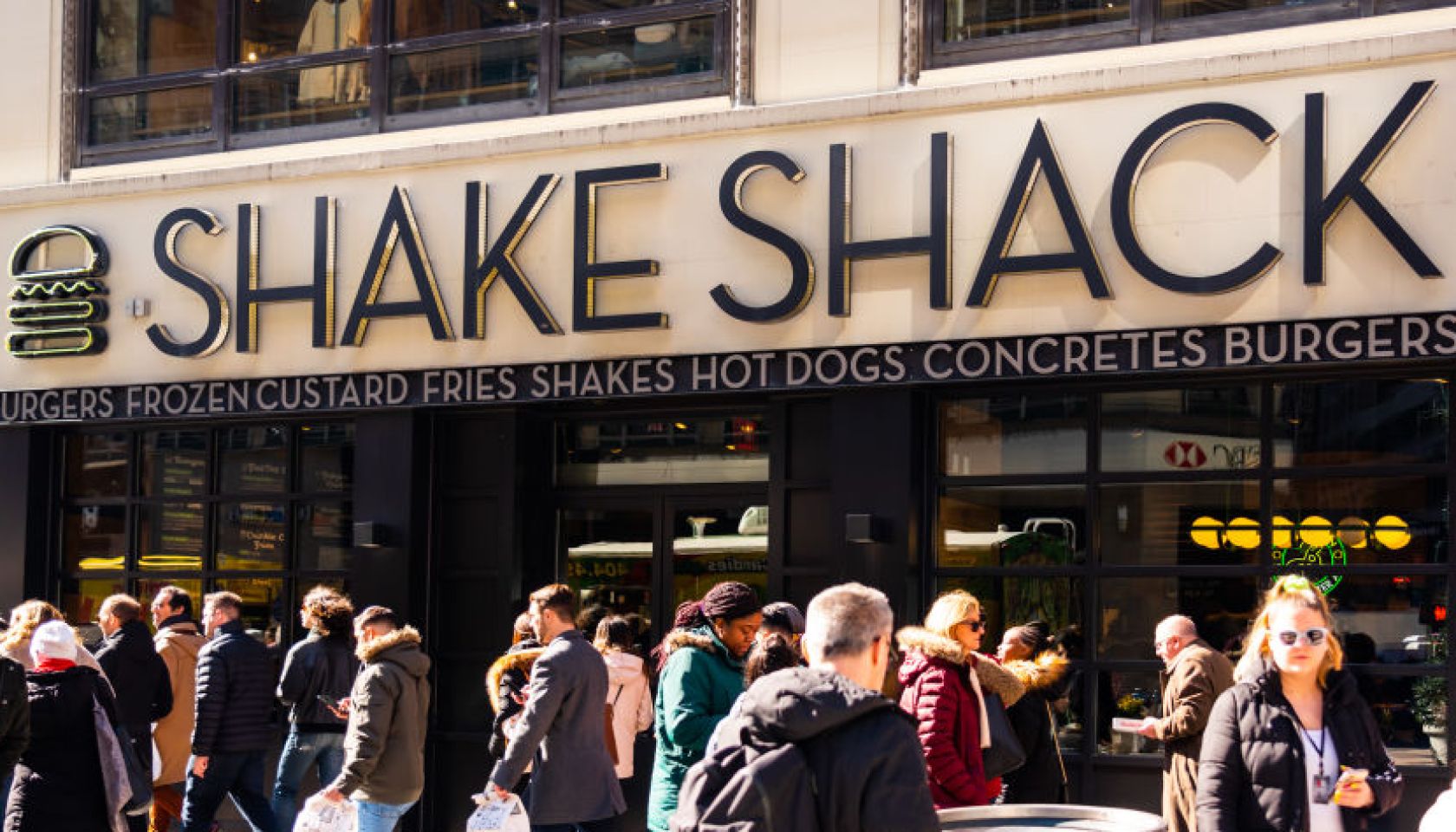 Pedestrians walk past an American fast casual restaurant...