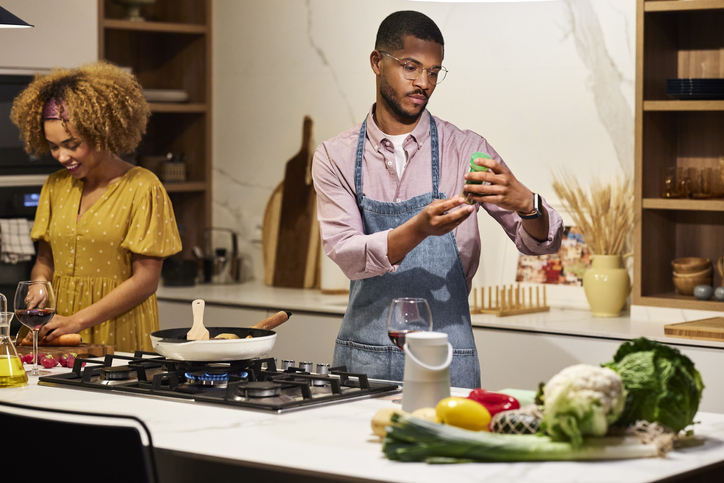 Man Examining Ingredient Bottle While Cooking