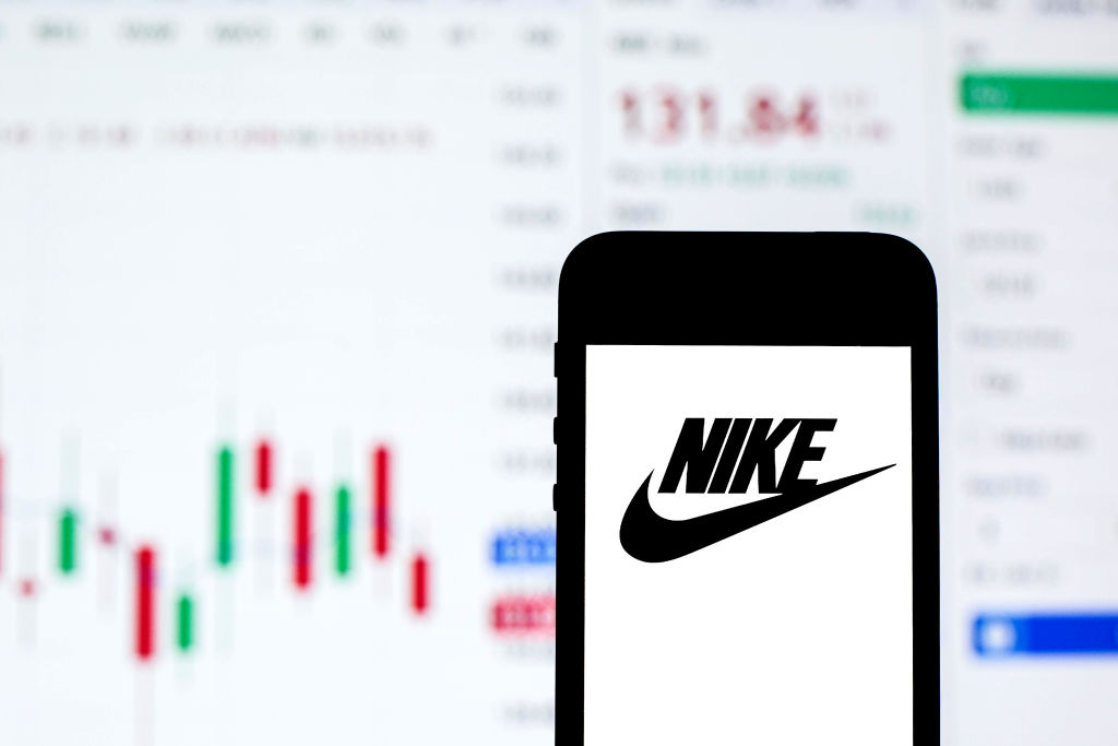 In this photo illustration a Nike logo seen displayed on a...