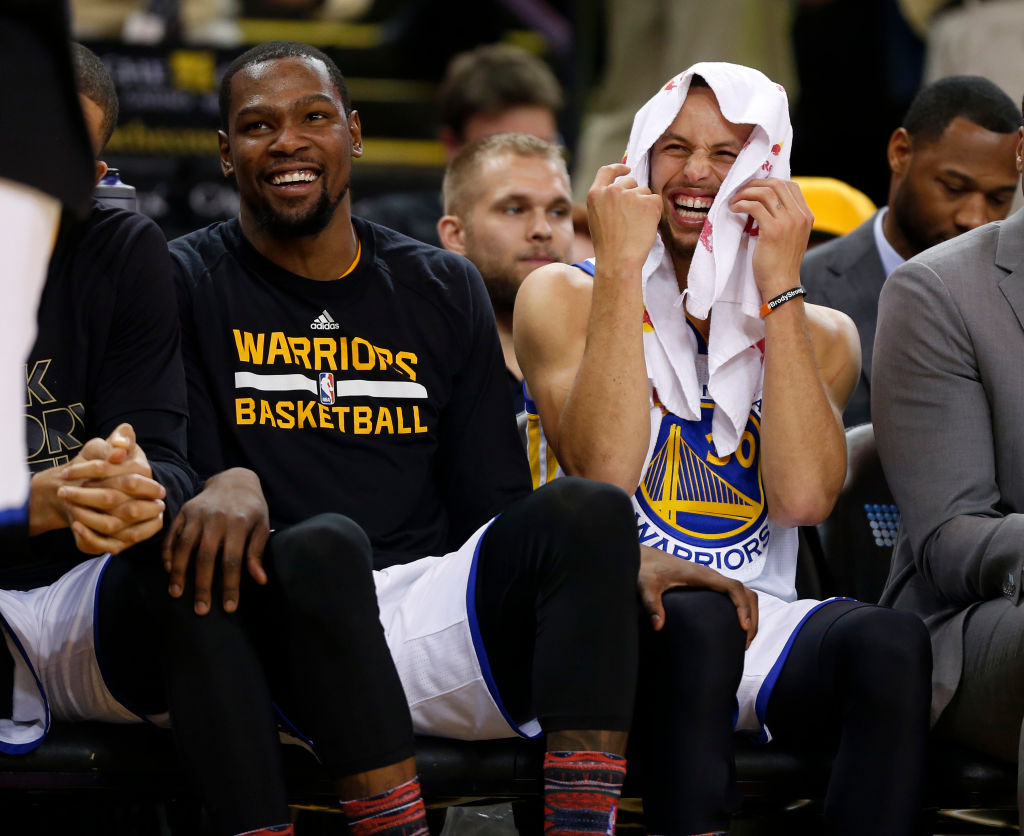 Golden State Warriors' Stephen Curry (30) laughs on the bench with Golden State Warriors' Kevin Durant (35) during their game against the Charlotte Hornets in the fourth quarter at Oracle Arena in Oakland, Calif. on Wednesday, Feb. 1, 2017. (Nhat V. Meyer