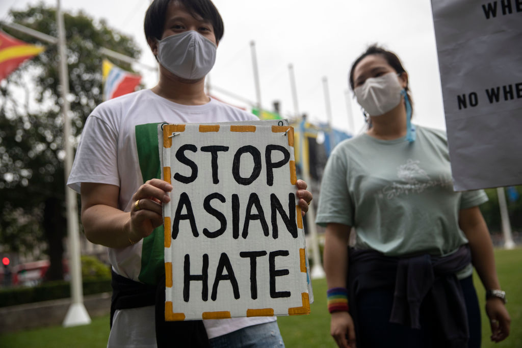 Protesters hold placards outside Parliament Square during...