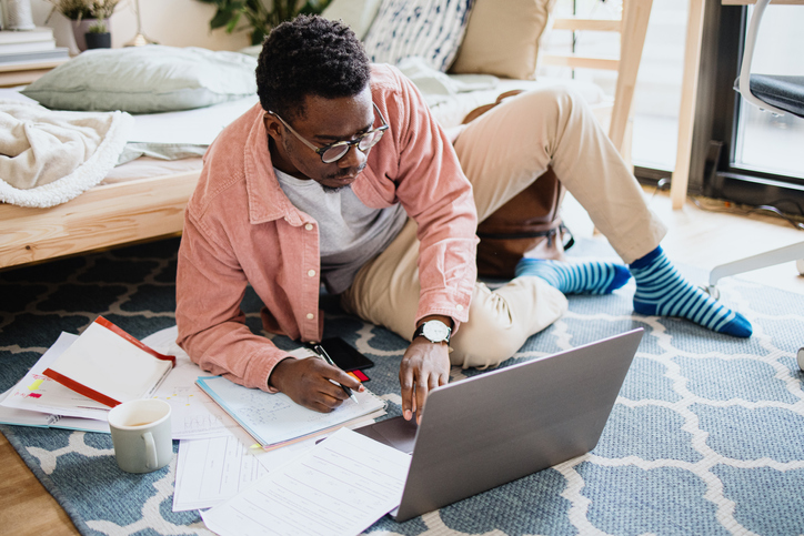 Young man using laptop working at home, studying online