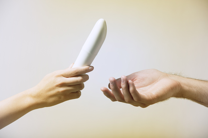 Woman handing man a vibrator