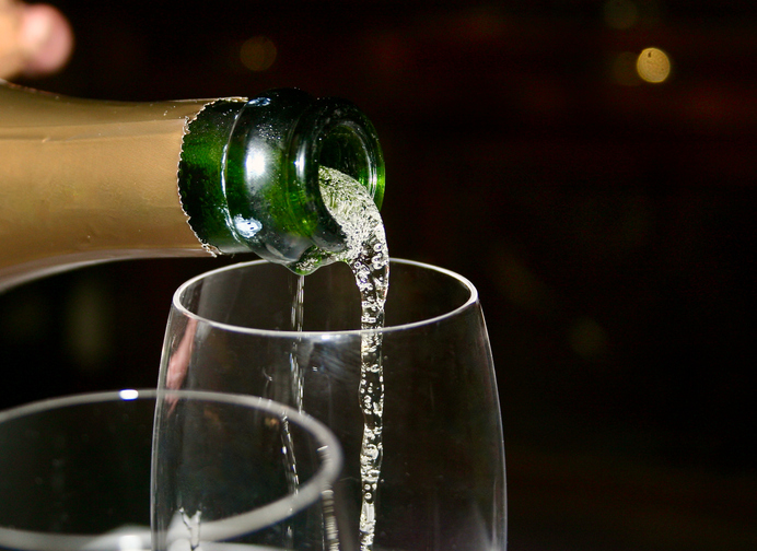 Closeup of a Server opening a bottle of champagne