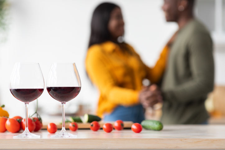 Unrecognizable Black Couple Dancing In Kitchen, Focus On Two Glasses Of Wine