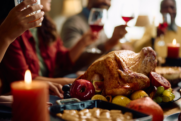 Thanksgiving turkey with family toasting in the background.