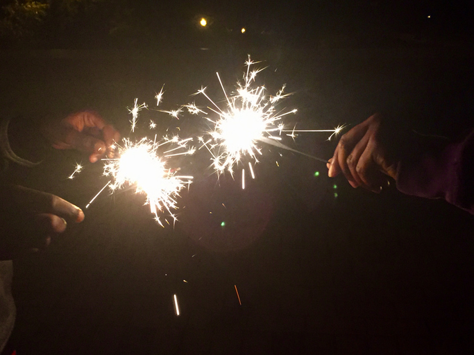 Youngsters playing with sparklers to celebrate July 4th USA Independence Day holiday