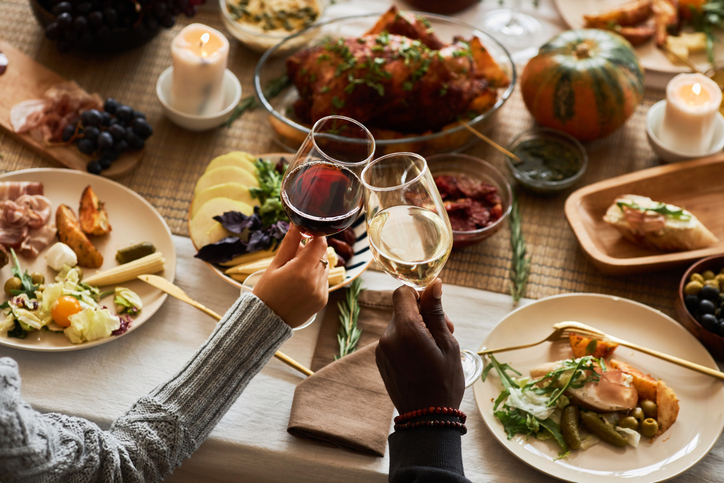 Close up of two people toasting celebrating Thanksgiving with friends and family