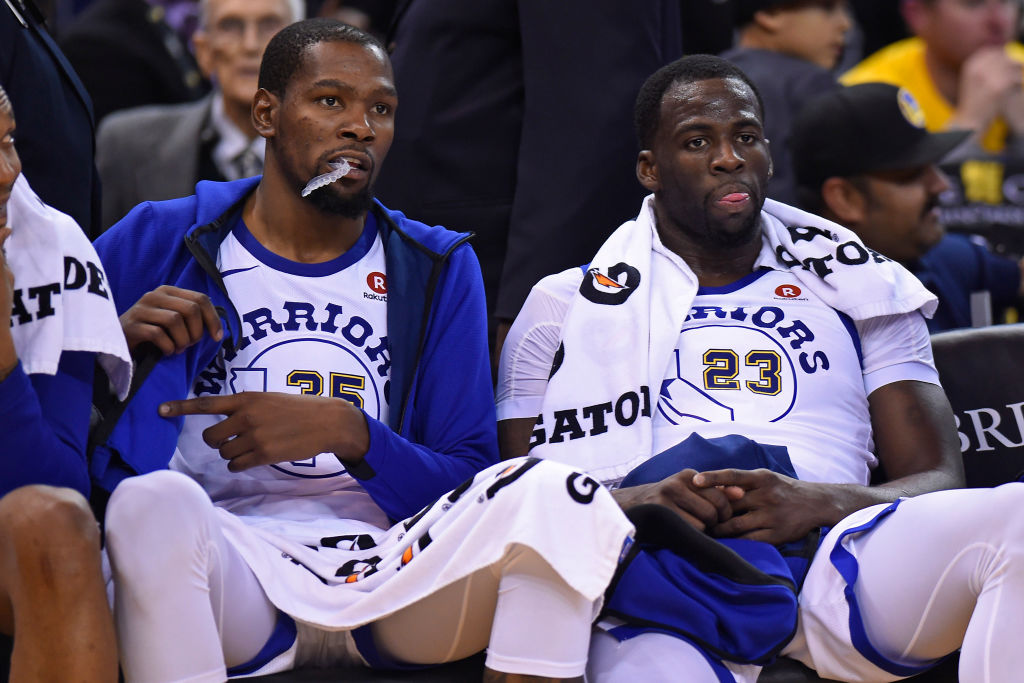Golden State Warriors' Kevin Durant (35) and Golden State Warriors' Draymond Green (23) sit on the bench during the final minute of the fourth quarter of their NBA game against the Charlotte Hornets at Oracle Arena in Oakland, Calif. on Friday, Dec. 29, 2