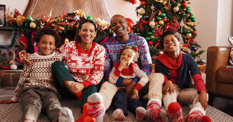 Family, laugh and portrait for Christmas, home and people on December holiday, bonding and together. Interracial, man and woman with children on Xmas, love and celebration for festive season in house