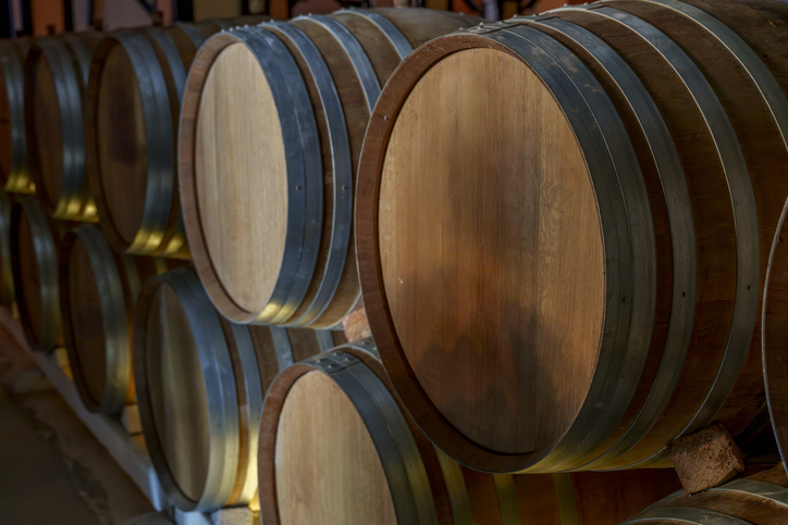 Row of oak wine barrels resting in dim cellar